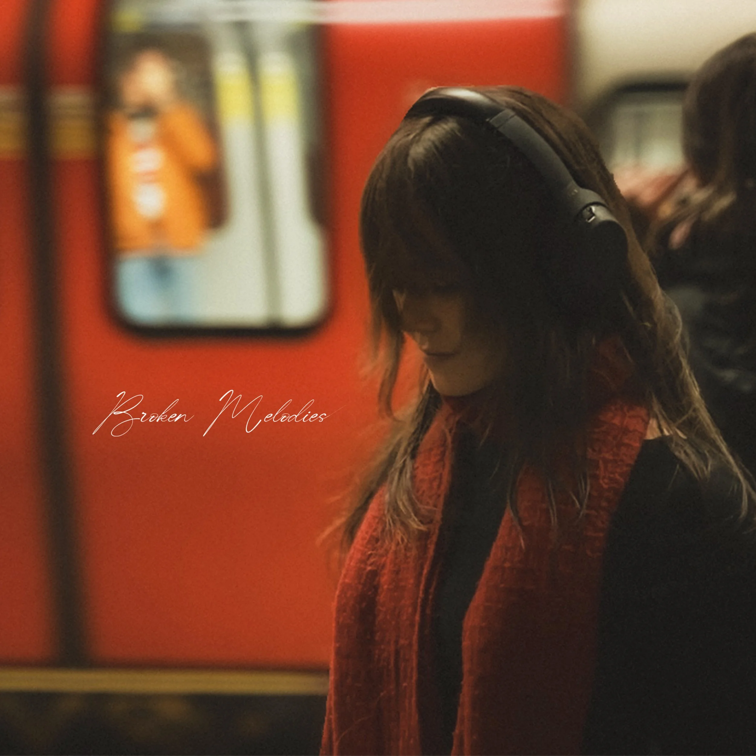 A woman in a red scarf looking down while standing in the London tube, with the words Broken Melodies written in script. The orange background is blurred as a train rushes by and people walk past.