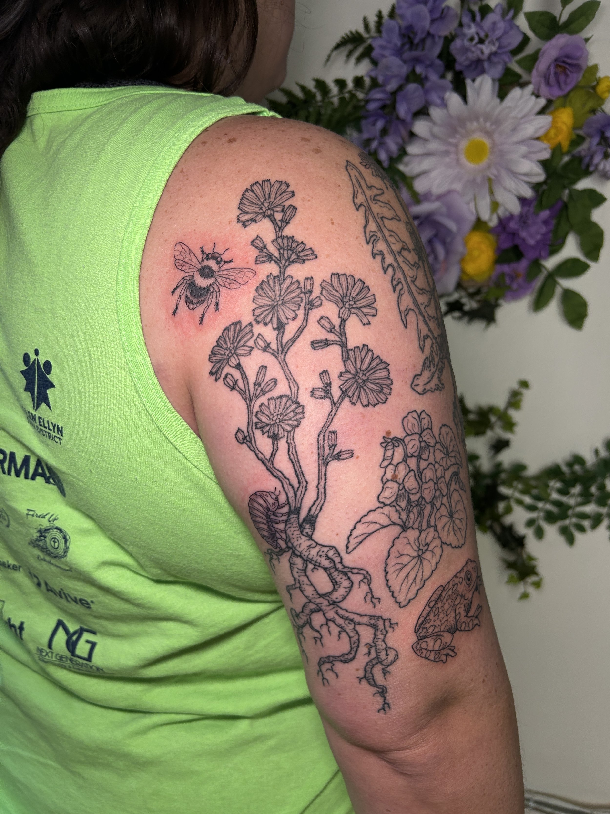 Healed linework botanical chicory and fresh bugs on nature-themed half-sleeve