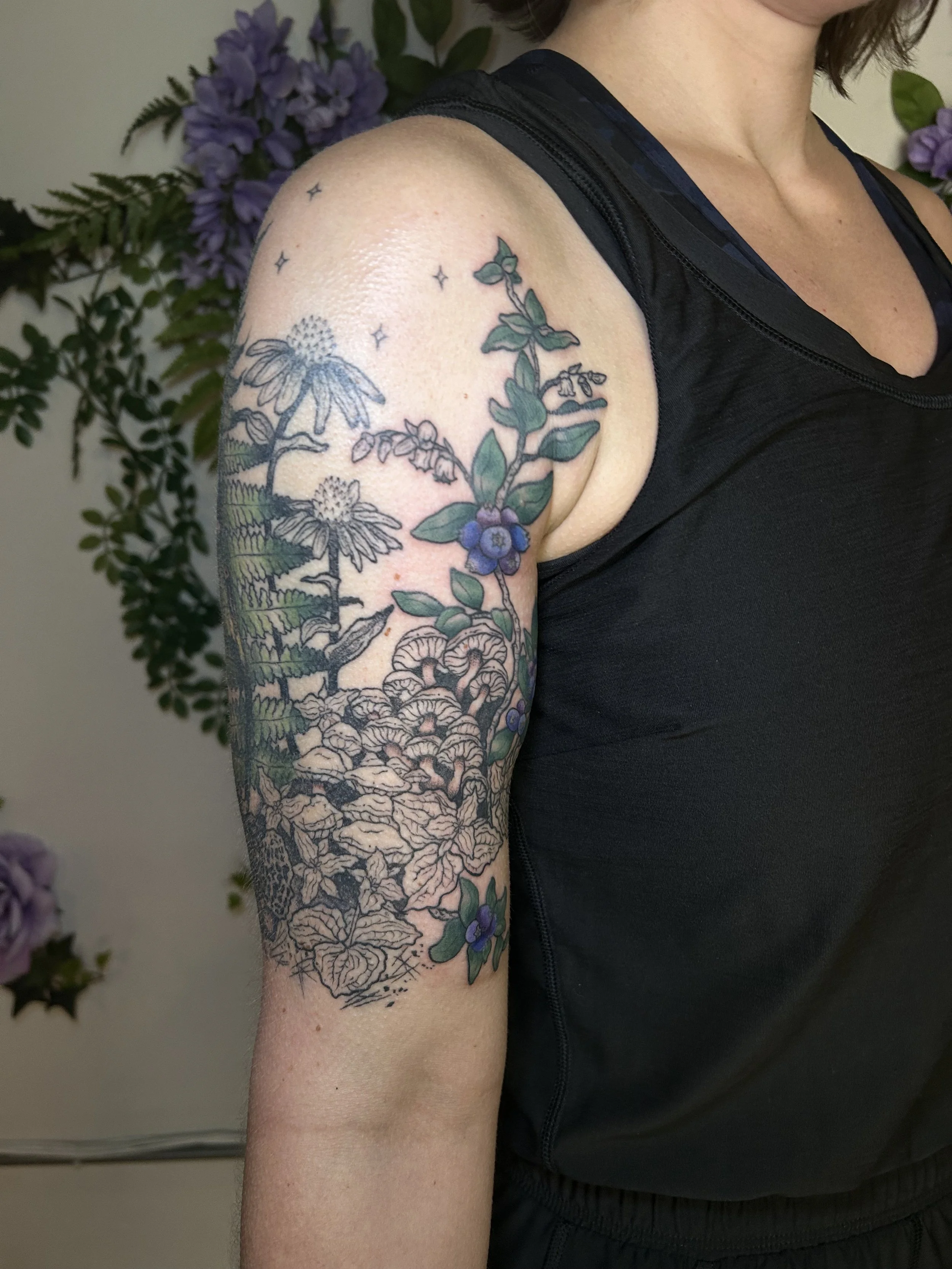 Illustrative botanical mushroom, fern, flower, and blueberry half-sleeve with black & grey shading and pops of color