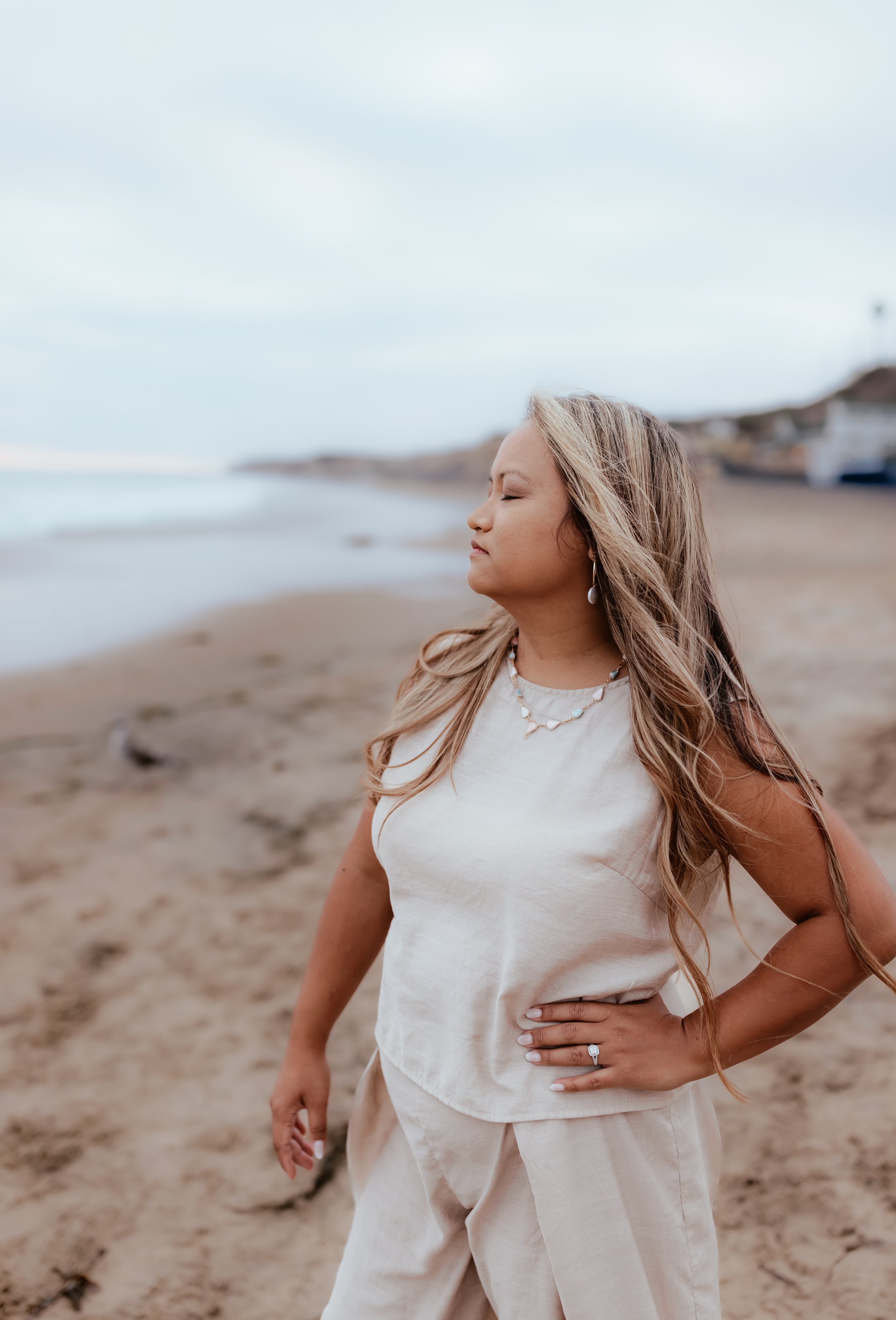 Emma Rose standing eyes closed on beach
