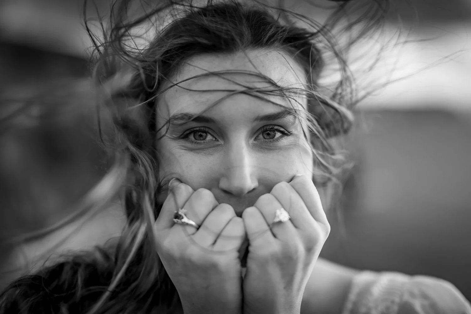 Emotional surprise proposal reaction captured at the Cliffs of Moher with engagement ring visible during a private proposal photoshoot.