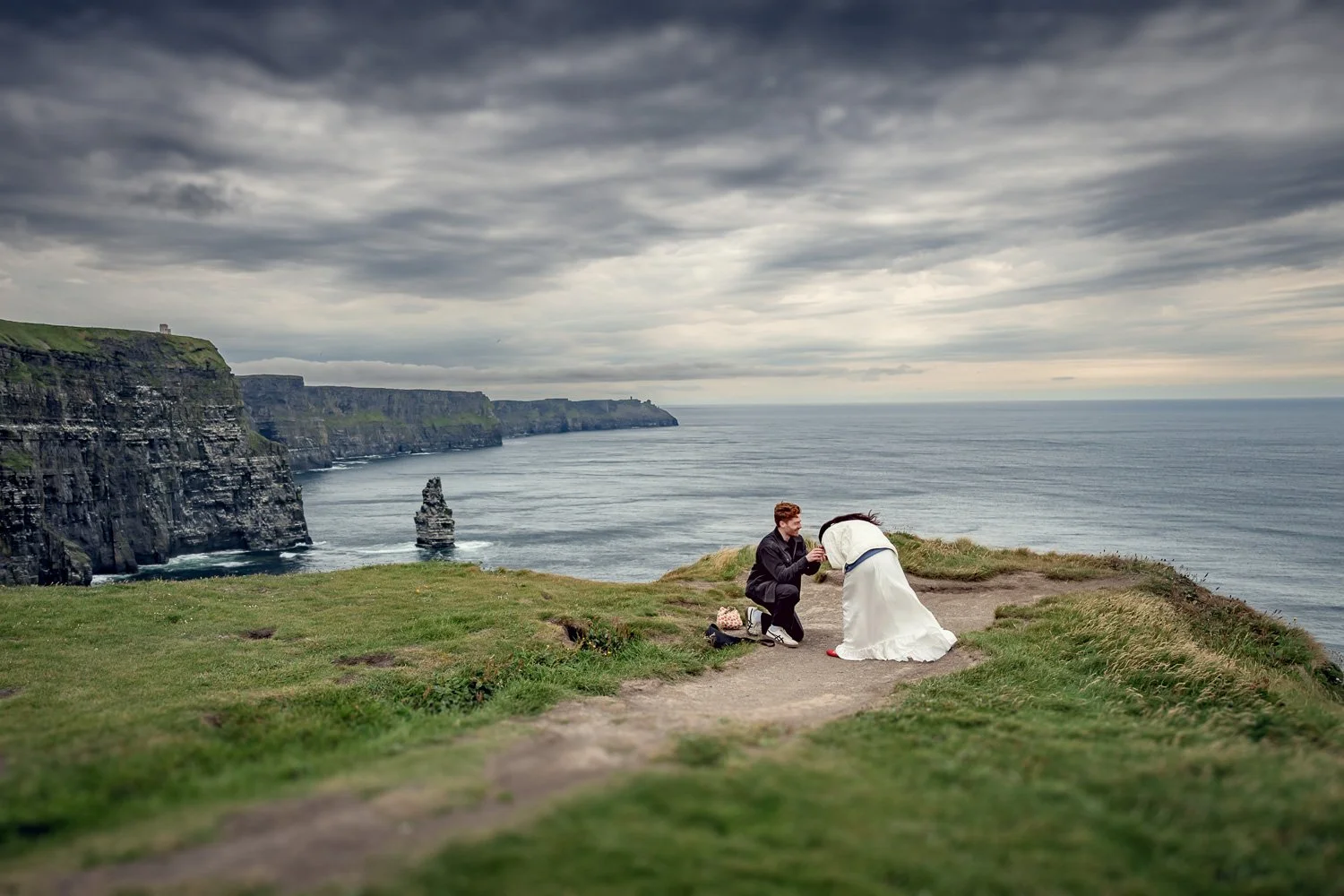 Surprise engagement proposal at the Cliffs of Moher with an emotional reaction captured against Ireland’s dramatic coastal cliffs.