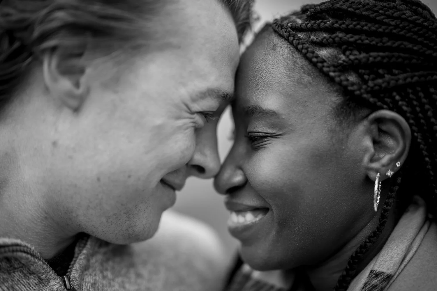 Intimate black and white engagement photo of a couple sharing a quiet moment during their Cliffs of Moher proposal experience in Ireland