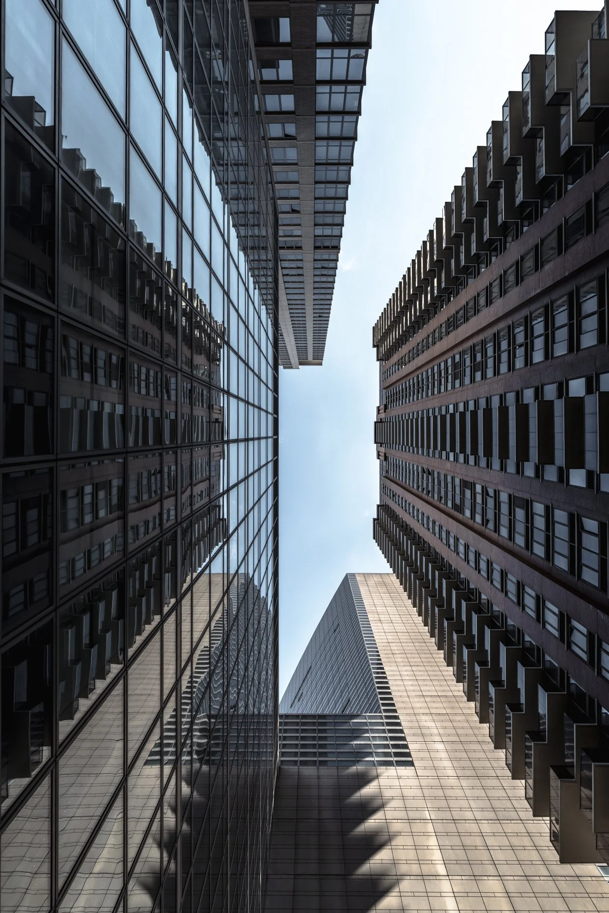 Looking up at four tall skyscrapers with glass and concrete facades in an urban city
