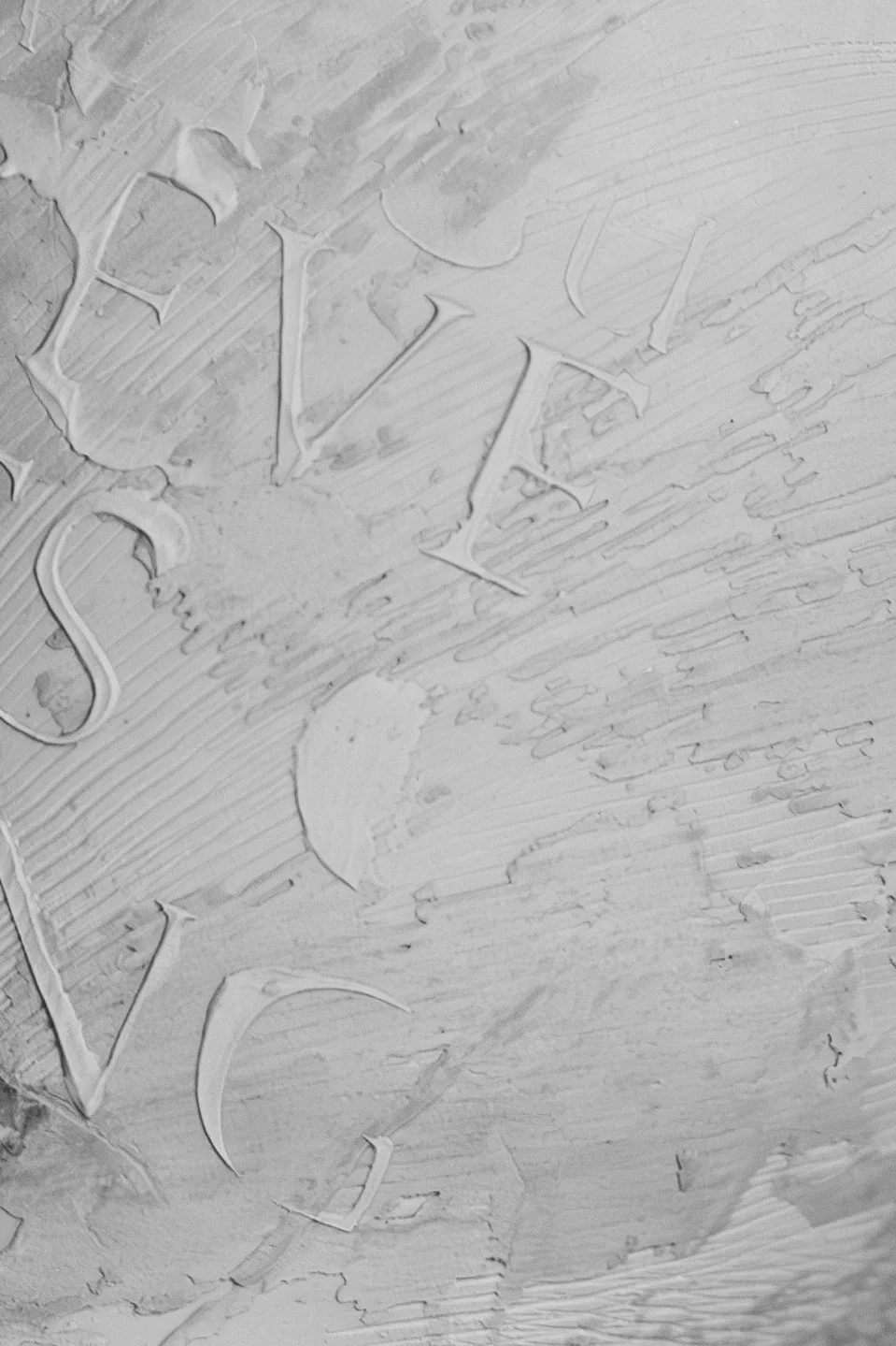 Close-up of the word 'SALE' carved into a textured wooden surface.