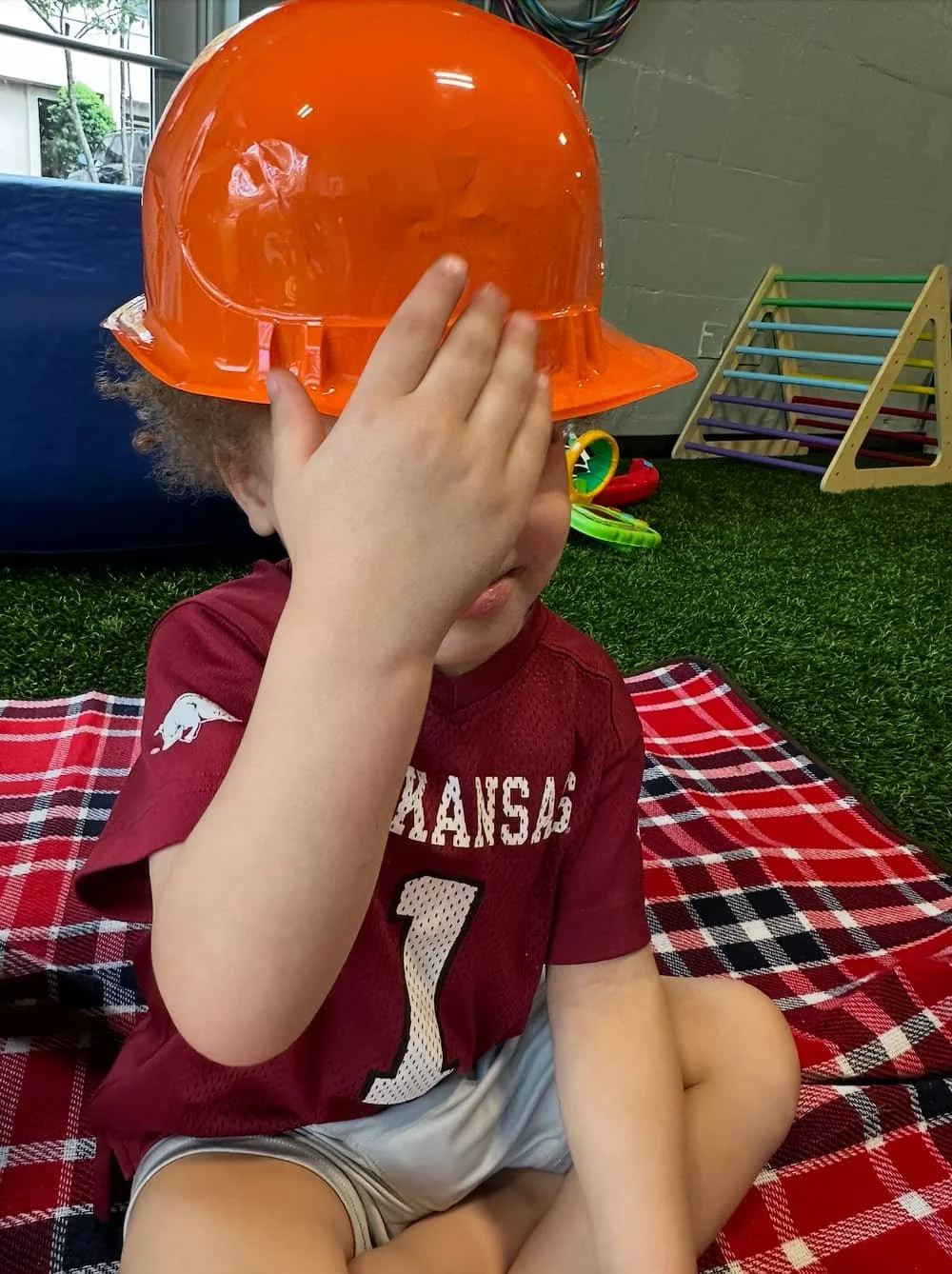 Child sitting with an Arkansas Razorback jersey at Kid Champion daycare and early childhood education center (infants and toddlers) in Little Rock, Arkansas.