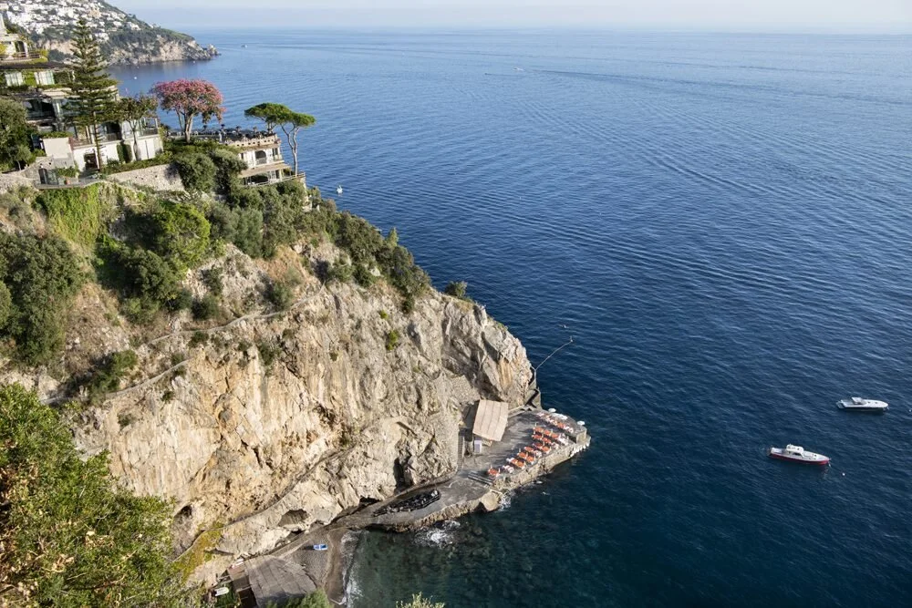 The private cove, beach club and dock below Il San Pietro di Positano seen from the cliff above