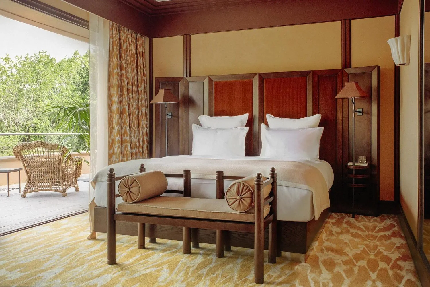 Guest room with mahogany panelling and open terrace doors at Mas Candille, Mougins