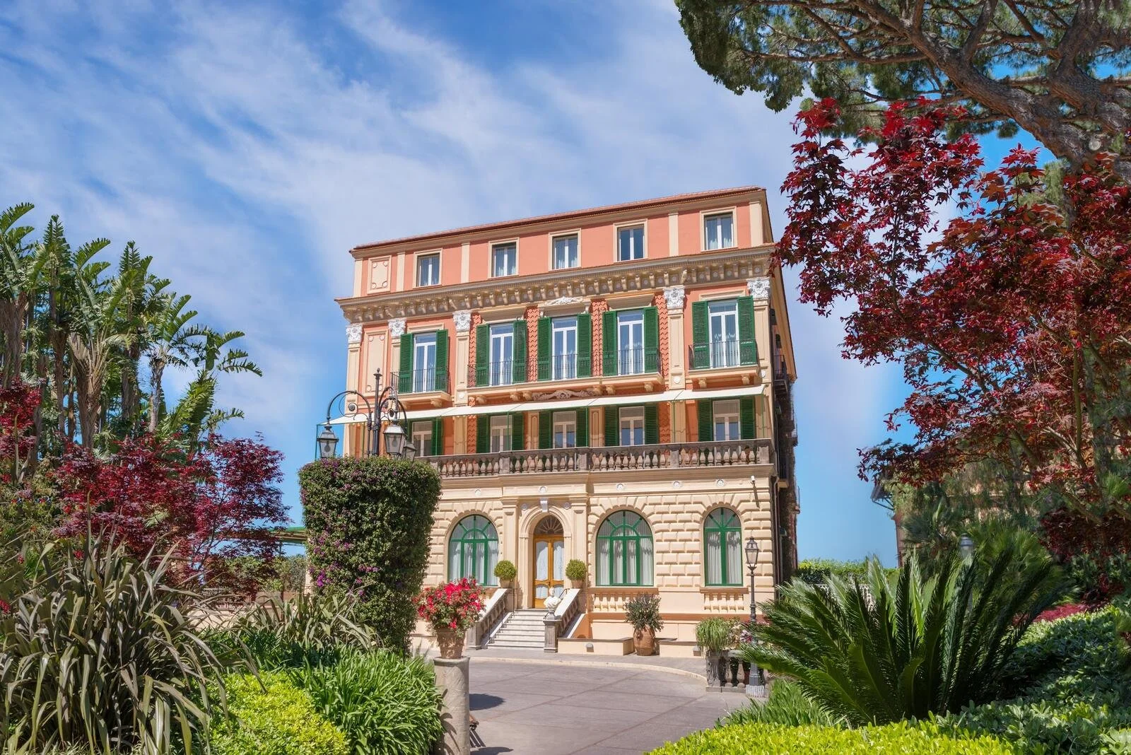 Facade of Grand Hotel Excelsior Vittoria in Sorrento seen through the hotel's private gardens
