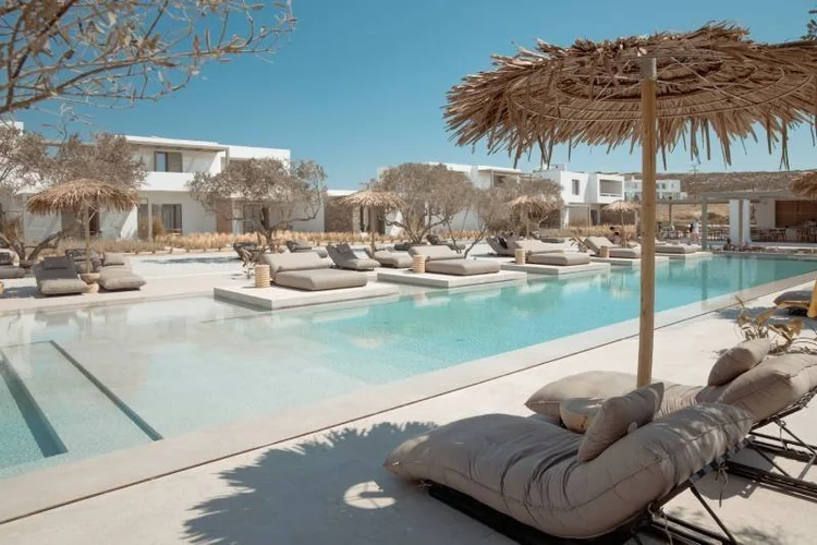 Cove Paros pool with olive trees and thatched umbrellas