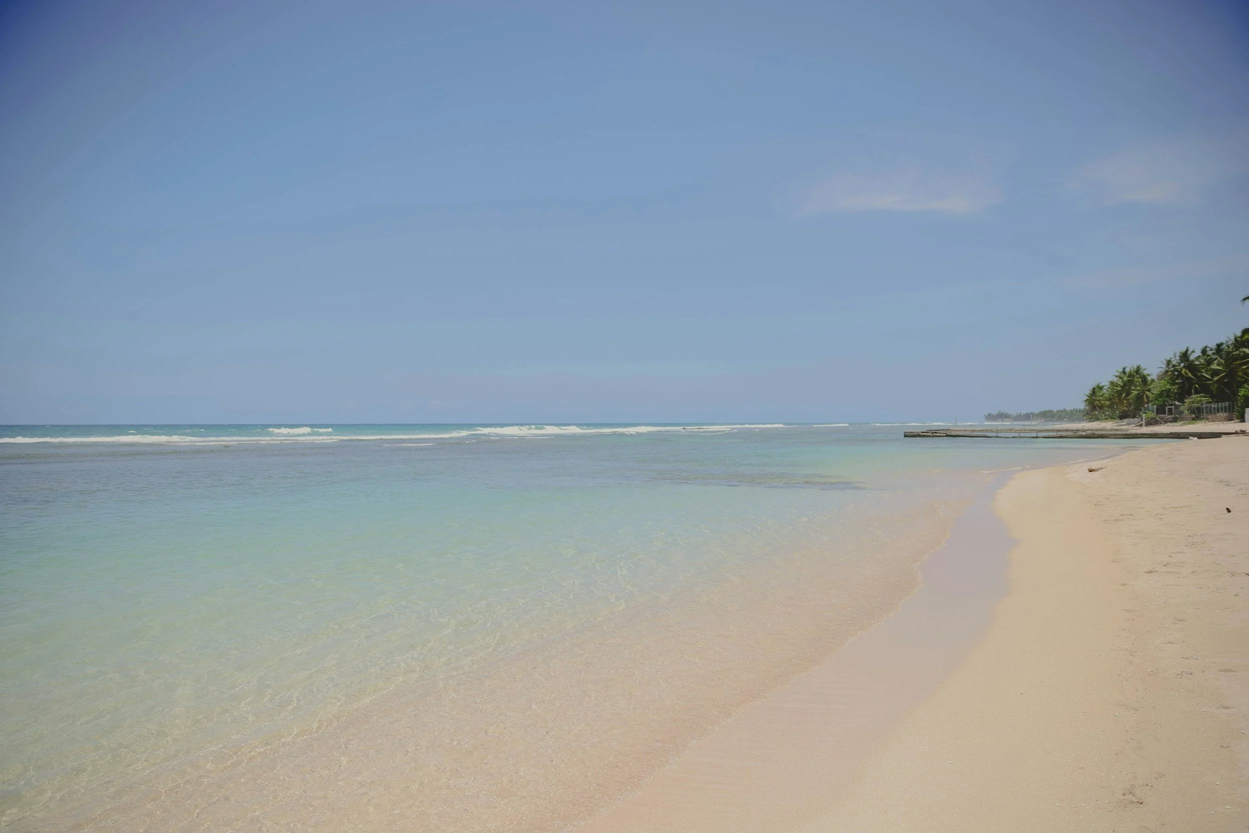 Clear turquoise shallows meeting pale sand on a calm morning, Dominican Republic