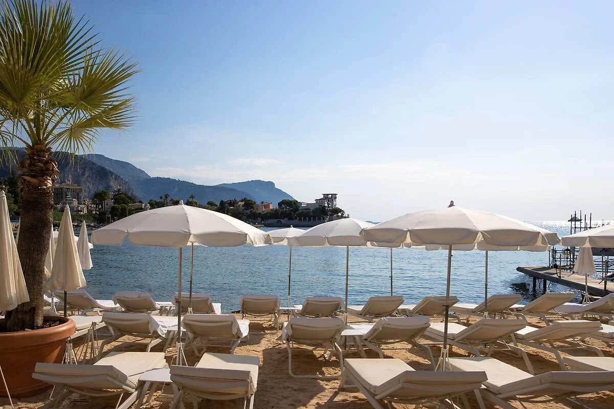 White parasols and loungers on the private sandy beach at Royal-Riviera, Saint-Jean-Cap-Ferrat