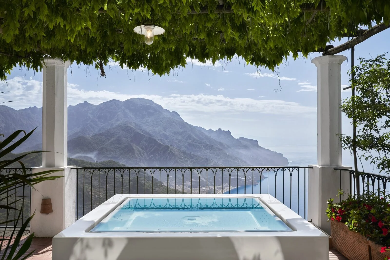 Rooftop whirlpool under a wisteria pergola at Palazzo Avino looking down the Amalfi Coast toward Minori