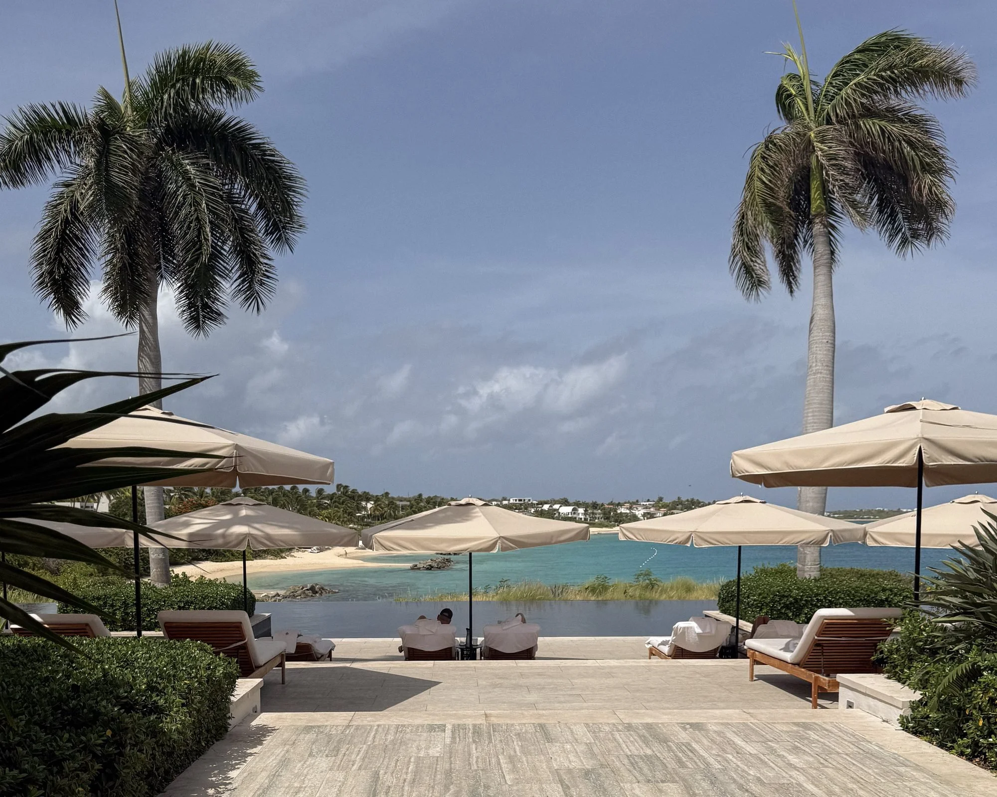 Sun loungers by the adults-only infinity pool overlooking Barnes Bay at Four Seasons Anguilla
