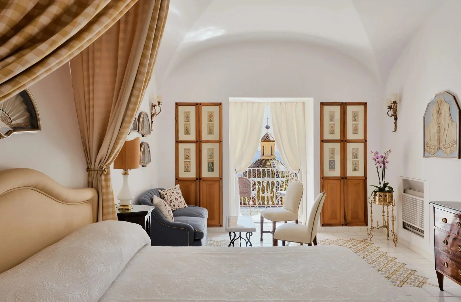 Sea view room at Le Sirenuse with a vaulted ceiling and balcony overlooking the dome of Santa Maria Assunta