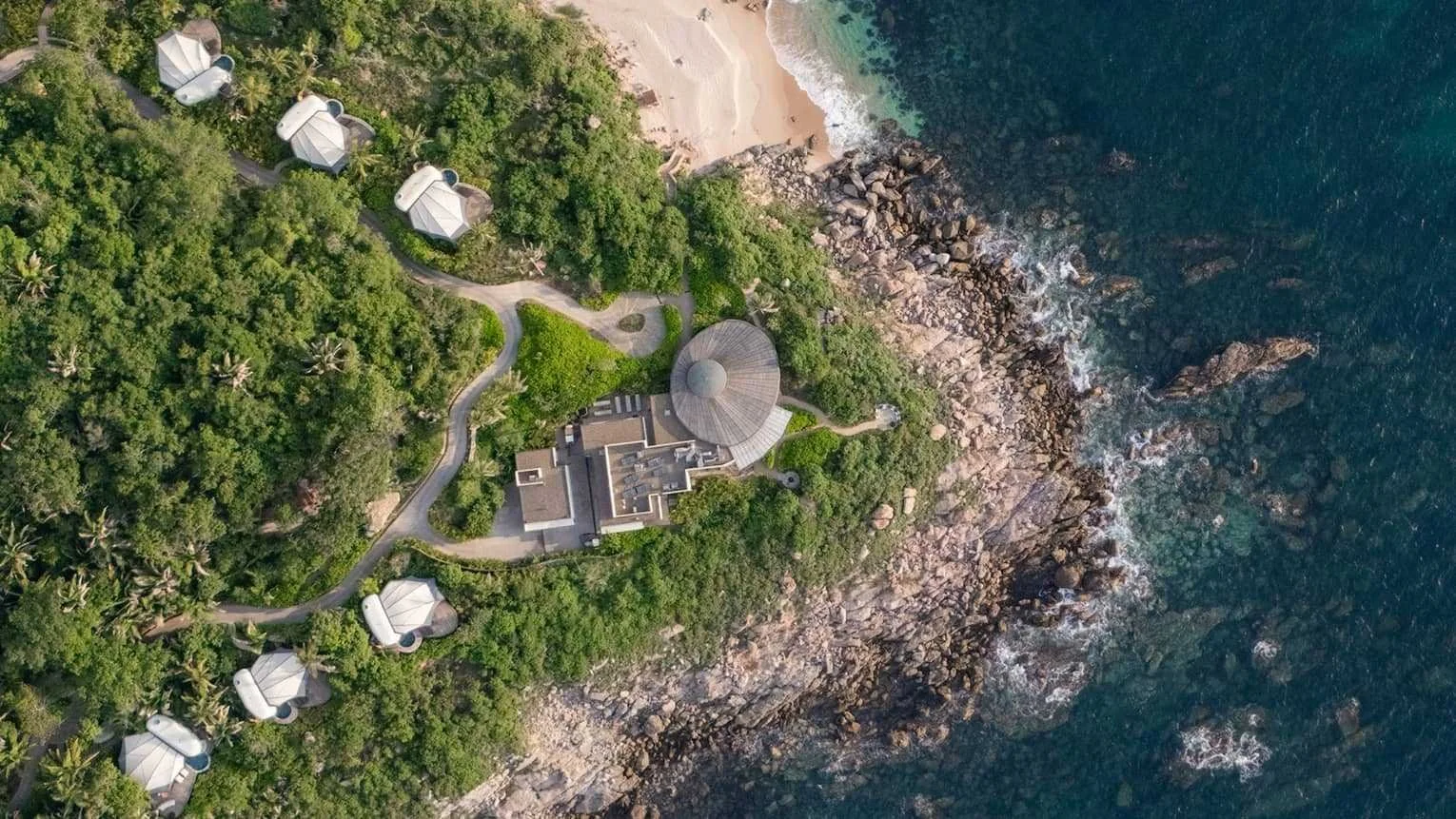 Aerial view of Naviva, a Four Seasons Resort in Punta Mita, Mexico, tented villas set among jungle along a rocky Pacific coastline.