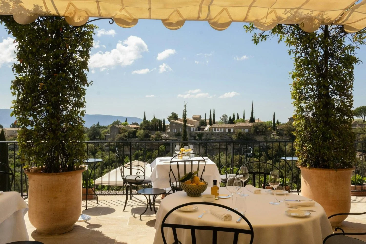 Restaurant terrace under a canvas awning with Luberon views at Airelles Gordes, La Bastide