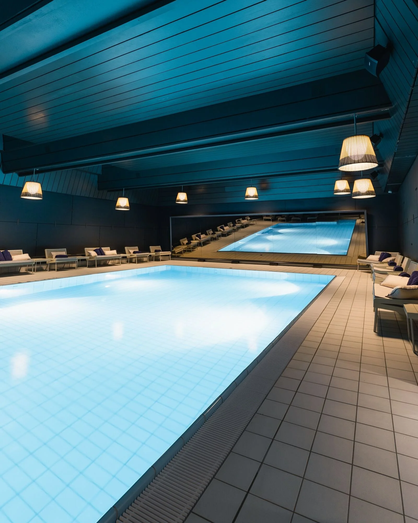 Heated 12-meter indoor swimming pool lined with relaxing lounge chairs at Schweizerhof Zermatt