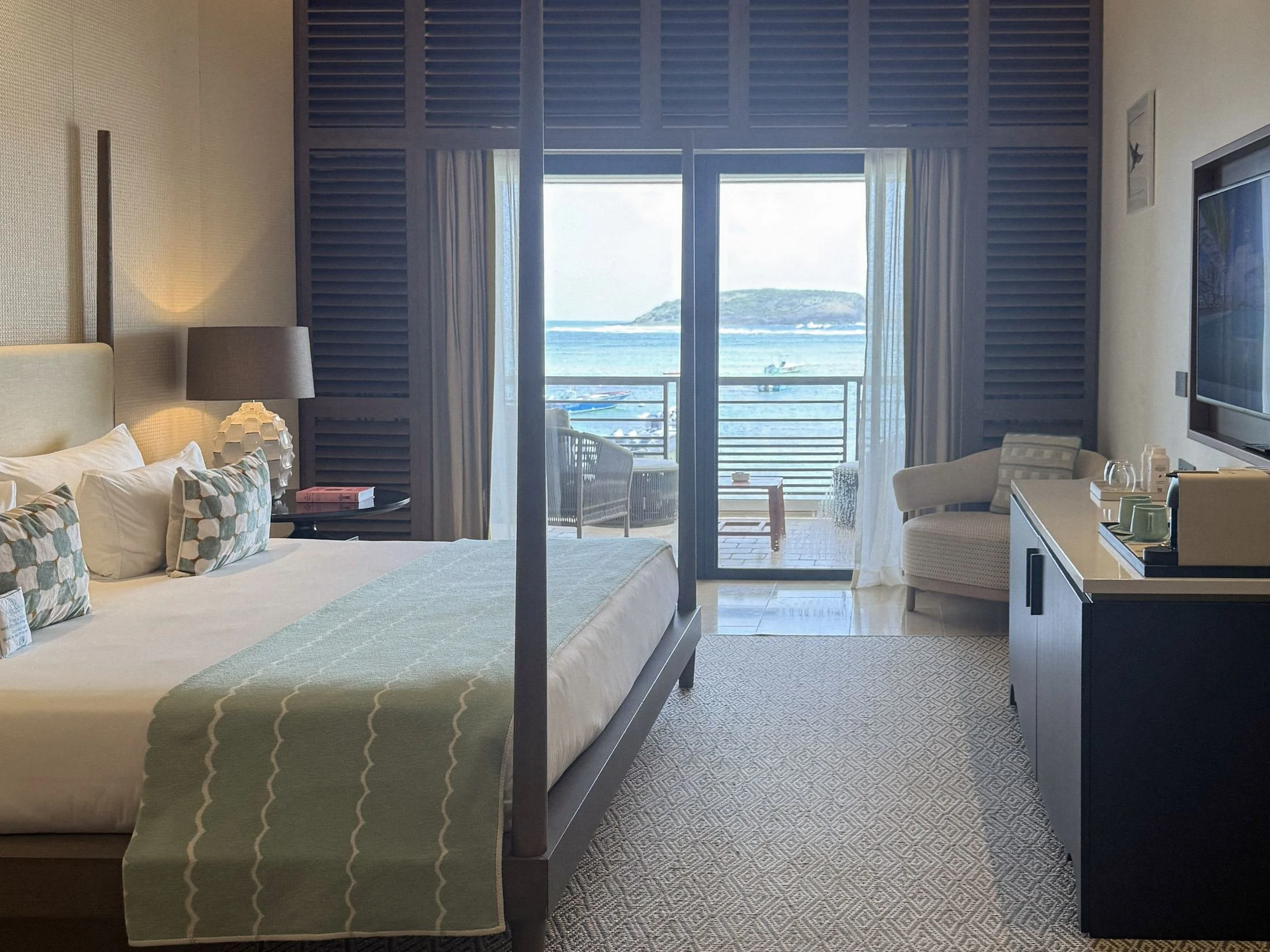 Guest room with four-poster bed and sea-view terrace at Le Barthélemy Hotel and Spa, St. Barth