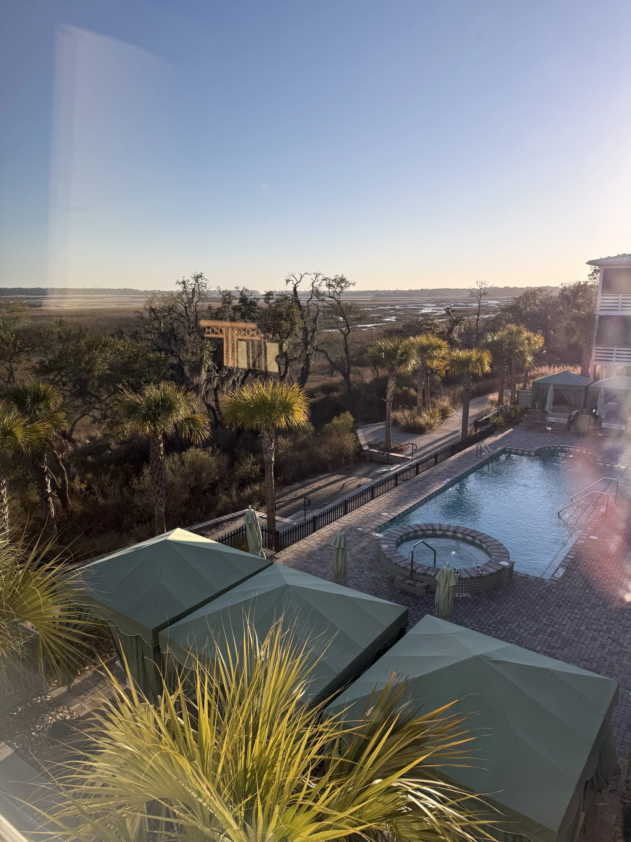 Pool and hot tub with green umbrellas overlooking the salt marsh at The Dunlin, Auberge Collection, South Carolina