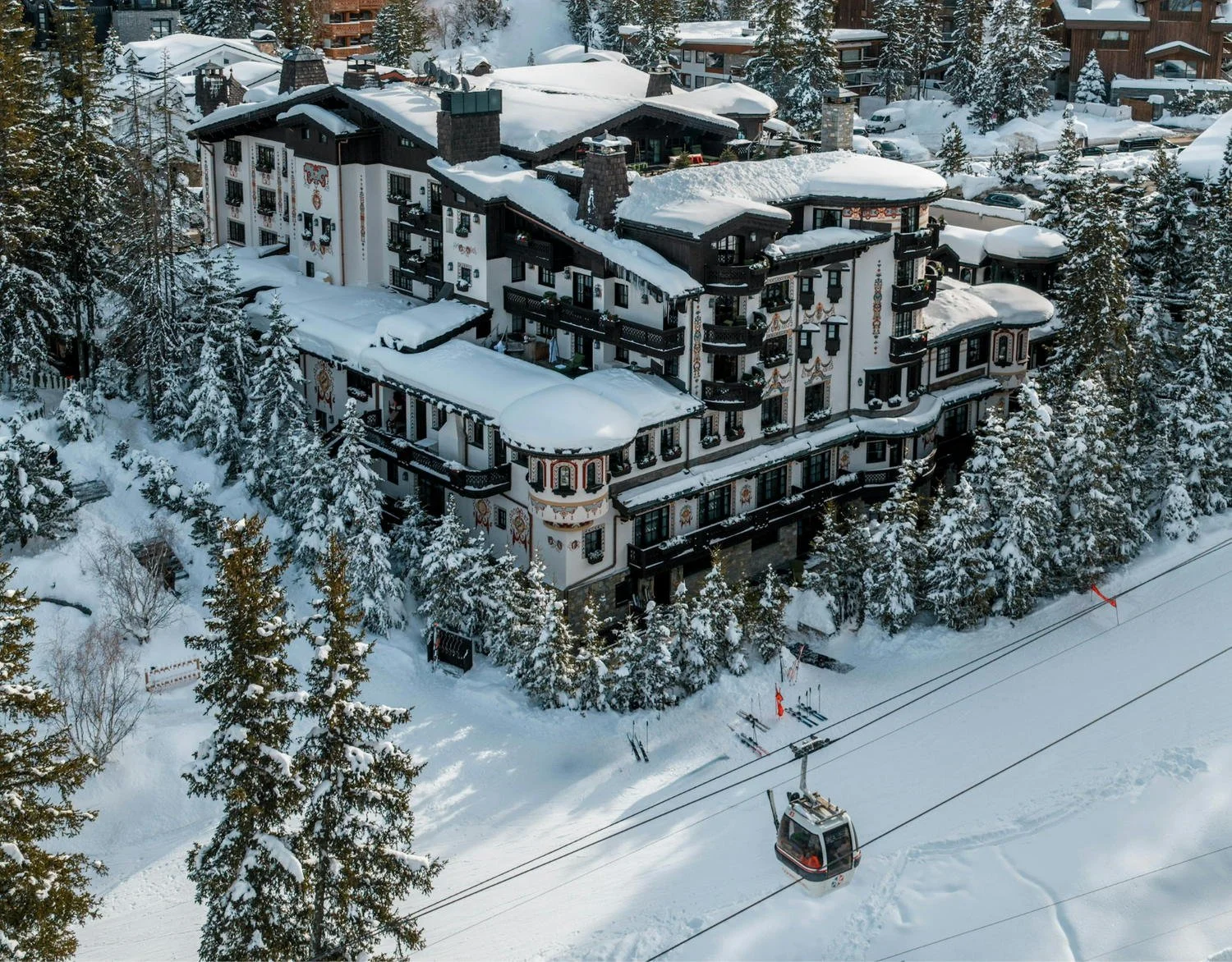 Aerial view of Airelles Courchevel in the Jardin Alpin with the gondola passing the hotel.