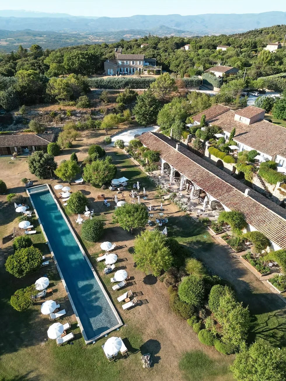 Aerial view of Capelongue above Bonnieux showing the 25 meter lap pool, gardens and stone buildings.