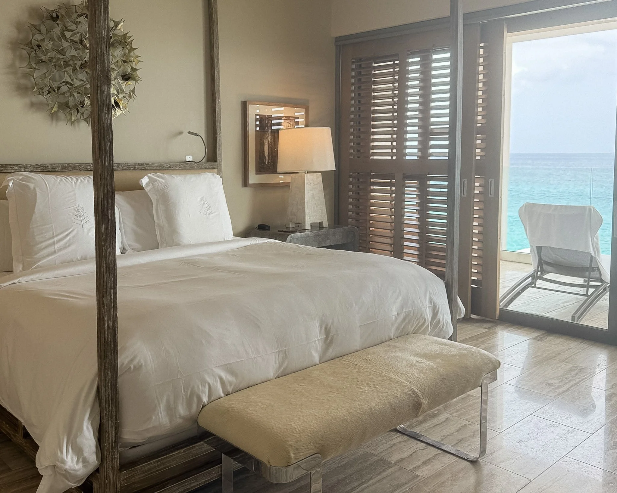 Kelly Wearstler designed ocean king residence bedroom at Four Seasons Anguilla with neutral tones and warm lighting