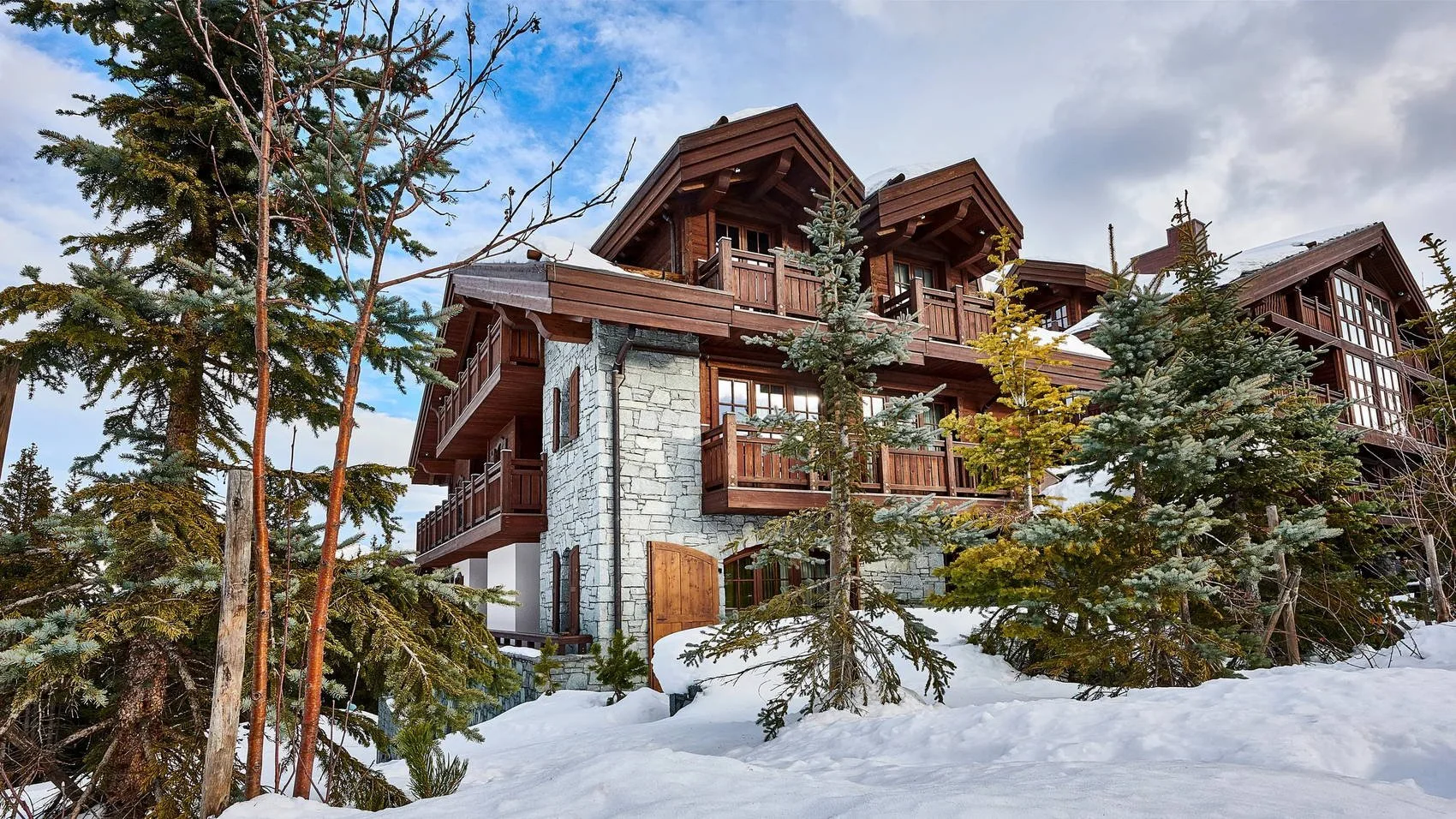 Exterior of the two private chalets alongside L’Apogée Courchevel in the snow.