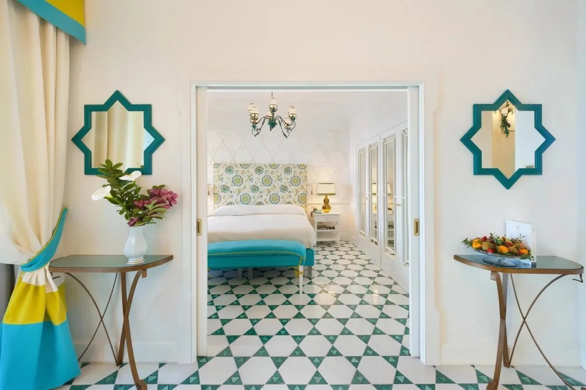 Bedroom and entry at Il San Pietro di Positano with a green and white majolica tile floor and turquoise details