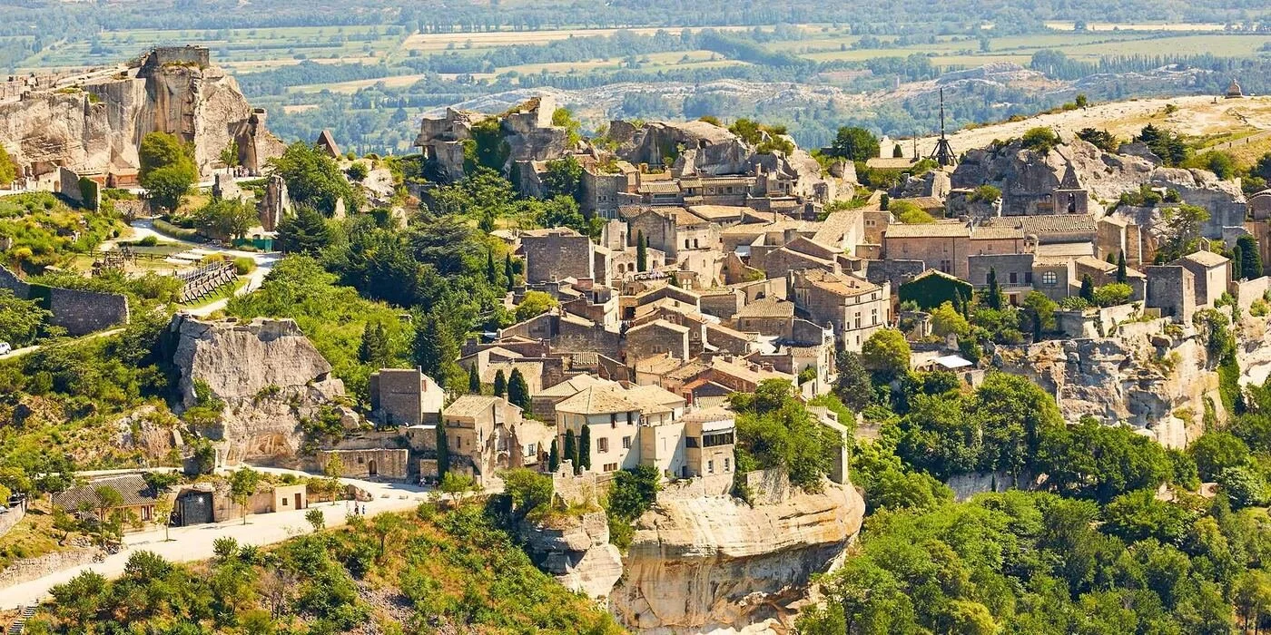 Craggy limestone cliffs and historic stone village structures of Les Baux-de-Provence set against the rocky Alpilles landscape.