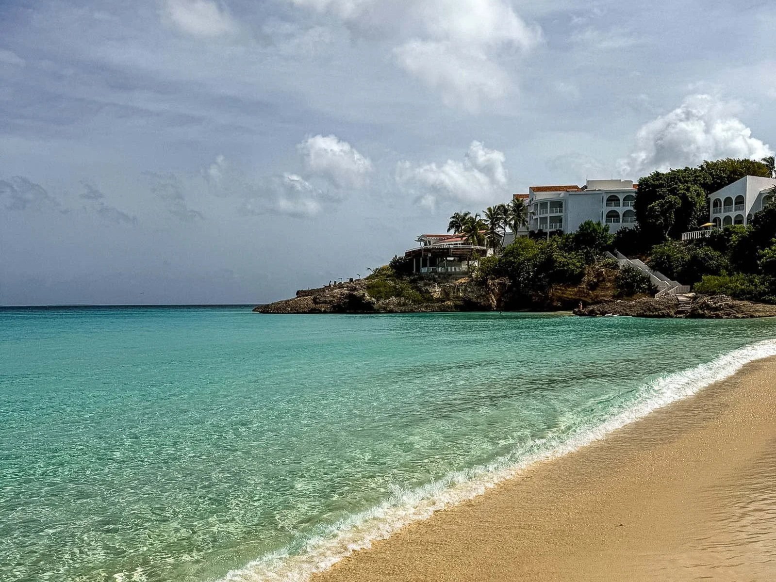 Malliouhana resort on the bluff above Meads Bay, Anguilla, seen from the sand at the water's edge on the author, Kate Van Dell's, last stay in Anguilla in July 2026