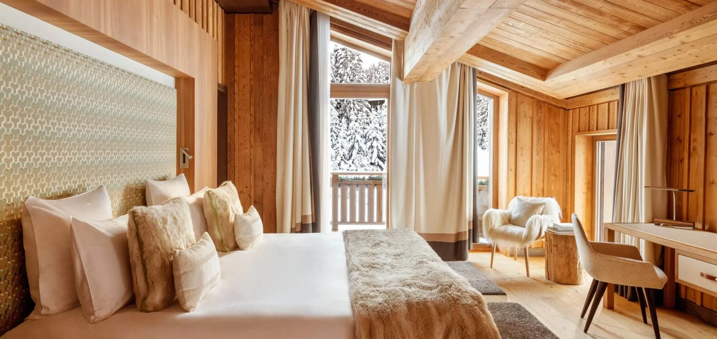Junior Suite bedroom with balcony and snow-covered pines at Cheval Blanc Courchevel