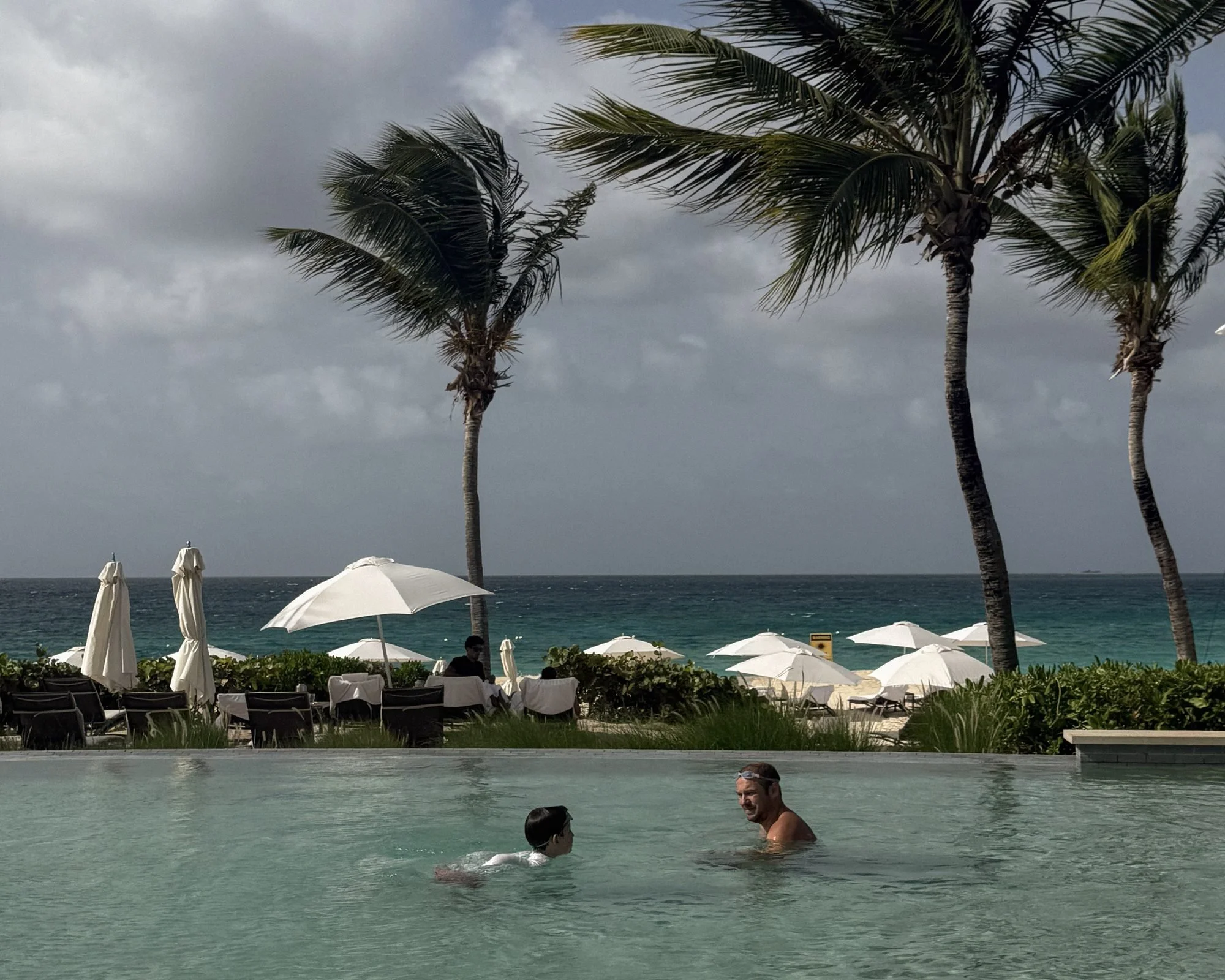 Author, Kate Van Dell's, husband and son  swimming in the family pool at Four Seasons Anguilla