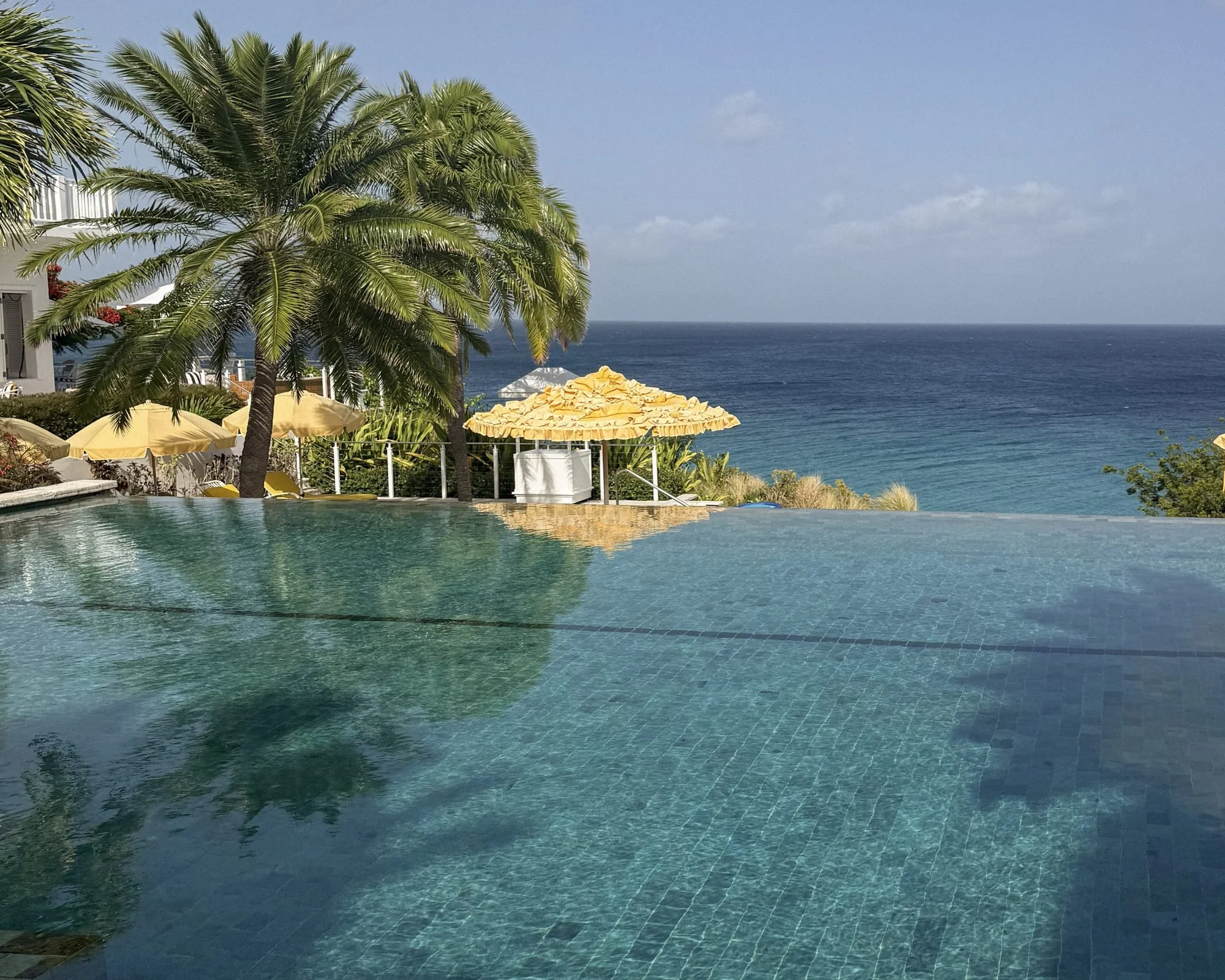 Infinity pool and yellow umbrellas above Meads Bay at Malliouhana Anguilla