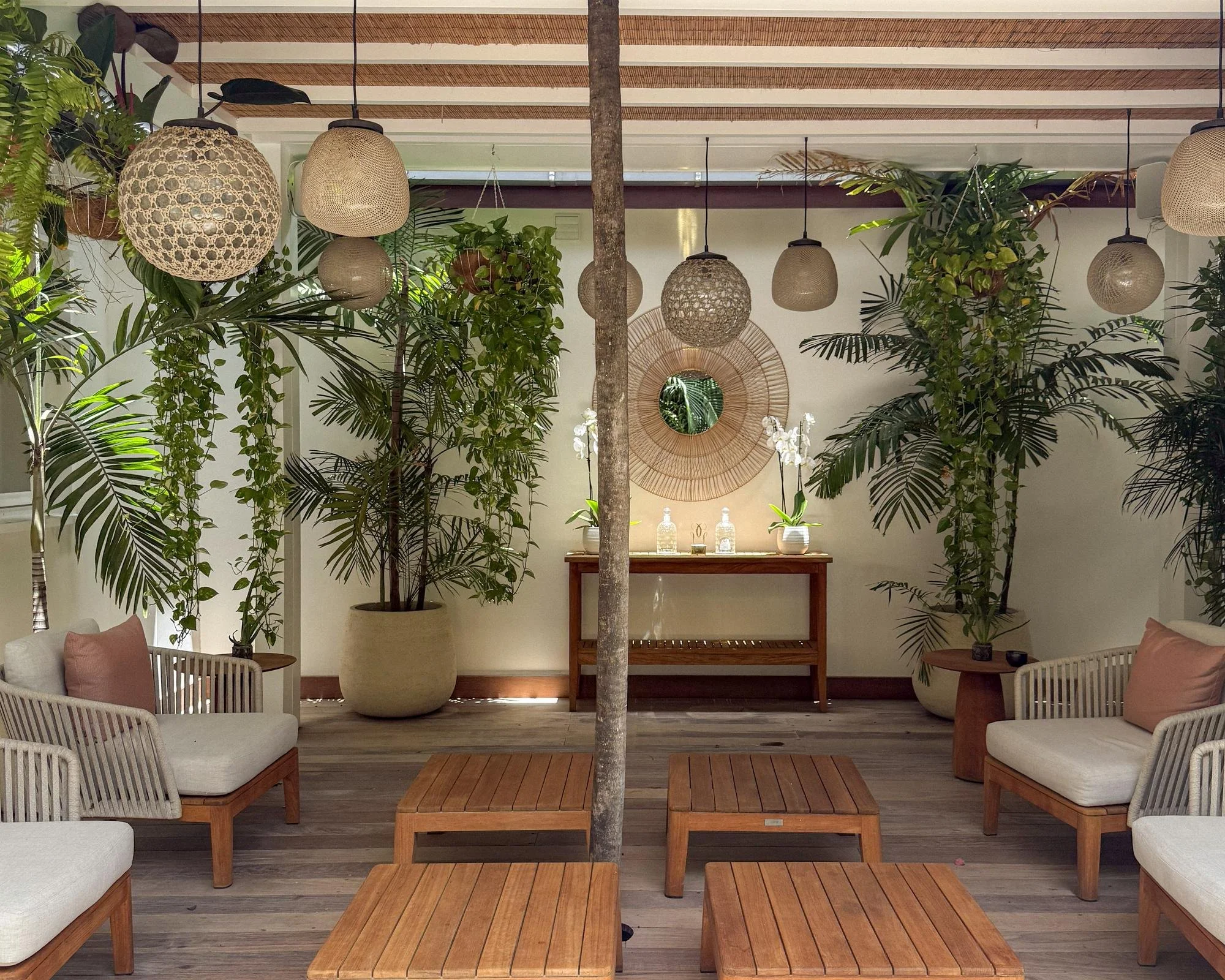 Open-sided Guerlain Spa relaxation lounge with rattan pendant lights and tropical foliage at Cheval Blanc St-Barth