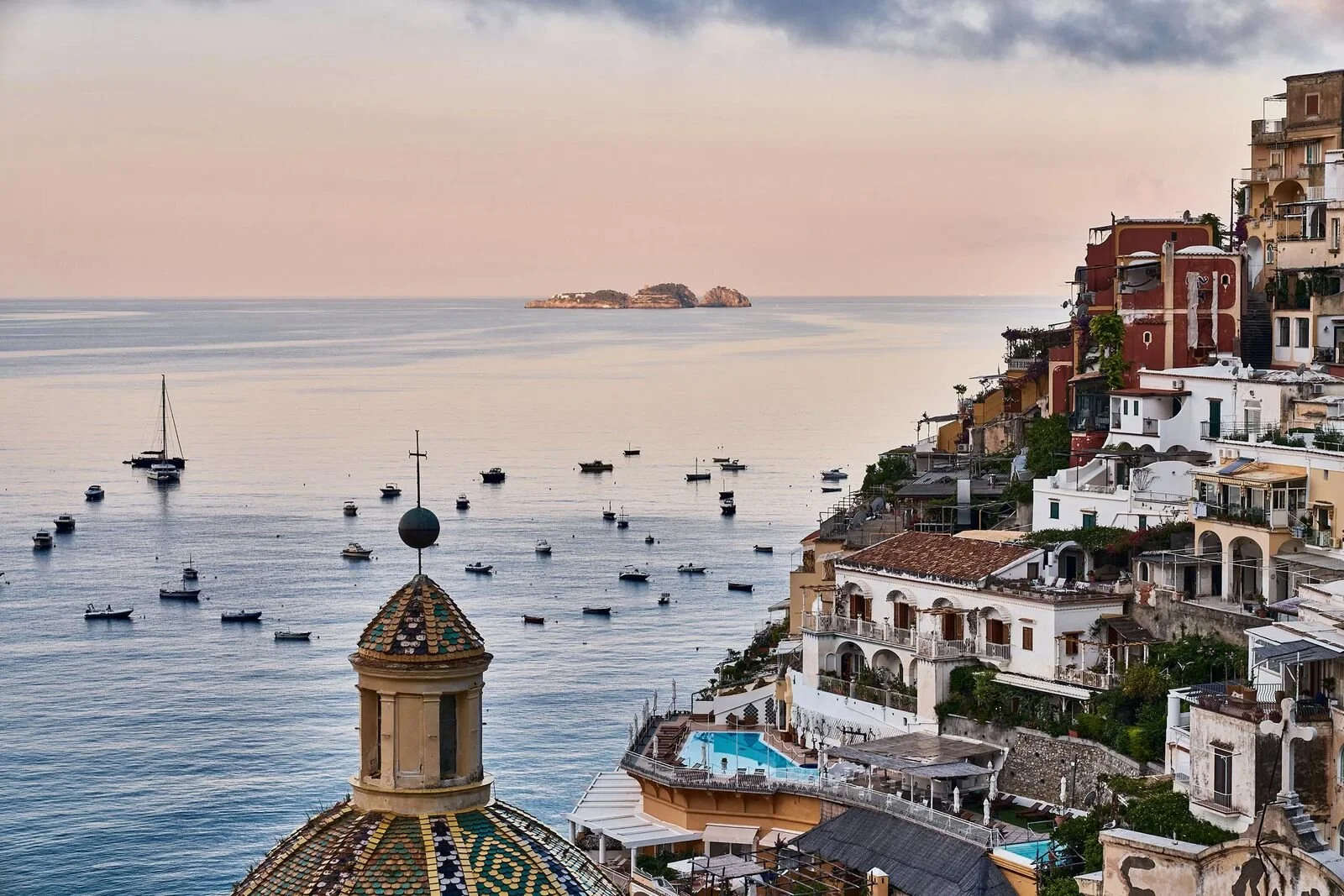 Sunrise over the bay at Positano seen from Le Sirenuse with the church dome and moored boats