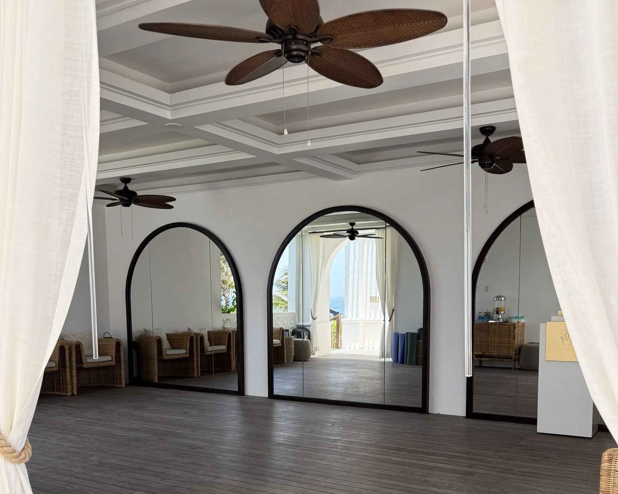 Open air yoga studio with arched mirrors and ceiling fans at Cap Juluca Anguilla