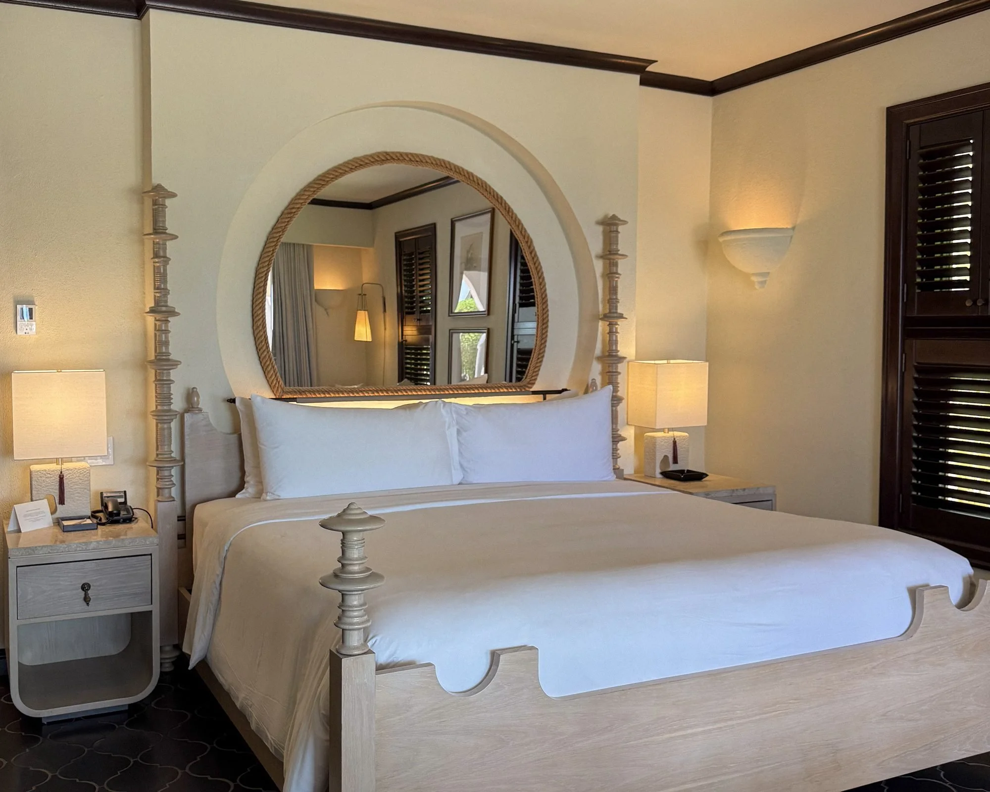 Guest room with king bed and round mirror at Cap Juluca Anguilla