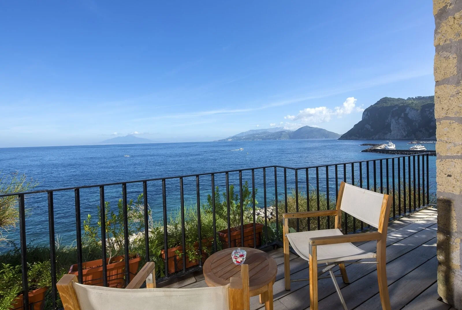 Private teak terrace at J.K. Place Capri looking across the bay toward Vesuvius and the Marina Grande breakwater