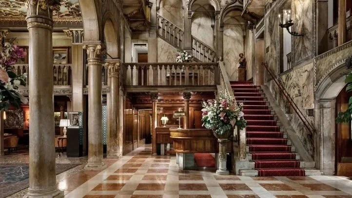 Marble columns, gilded ceiling and red-carpeted staircase in the historic lobby of Danieli, Venezia, A Four Seasons Hotel