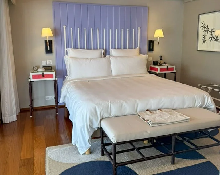 Bright guest room interior decorated in colorful lavender and coral accents.