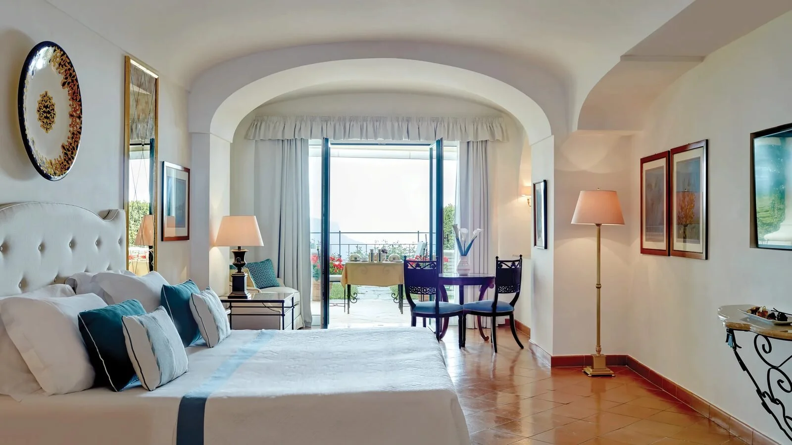 Habitación Deluxe con vistas al mar en el Caruso de Ravello, con suelos de terracota y puertas que dan a una terraza privada