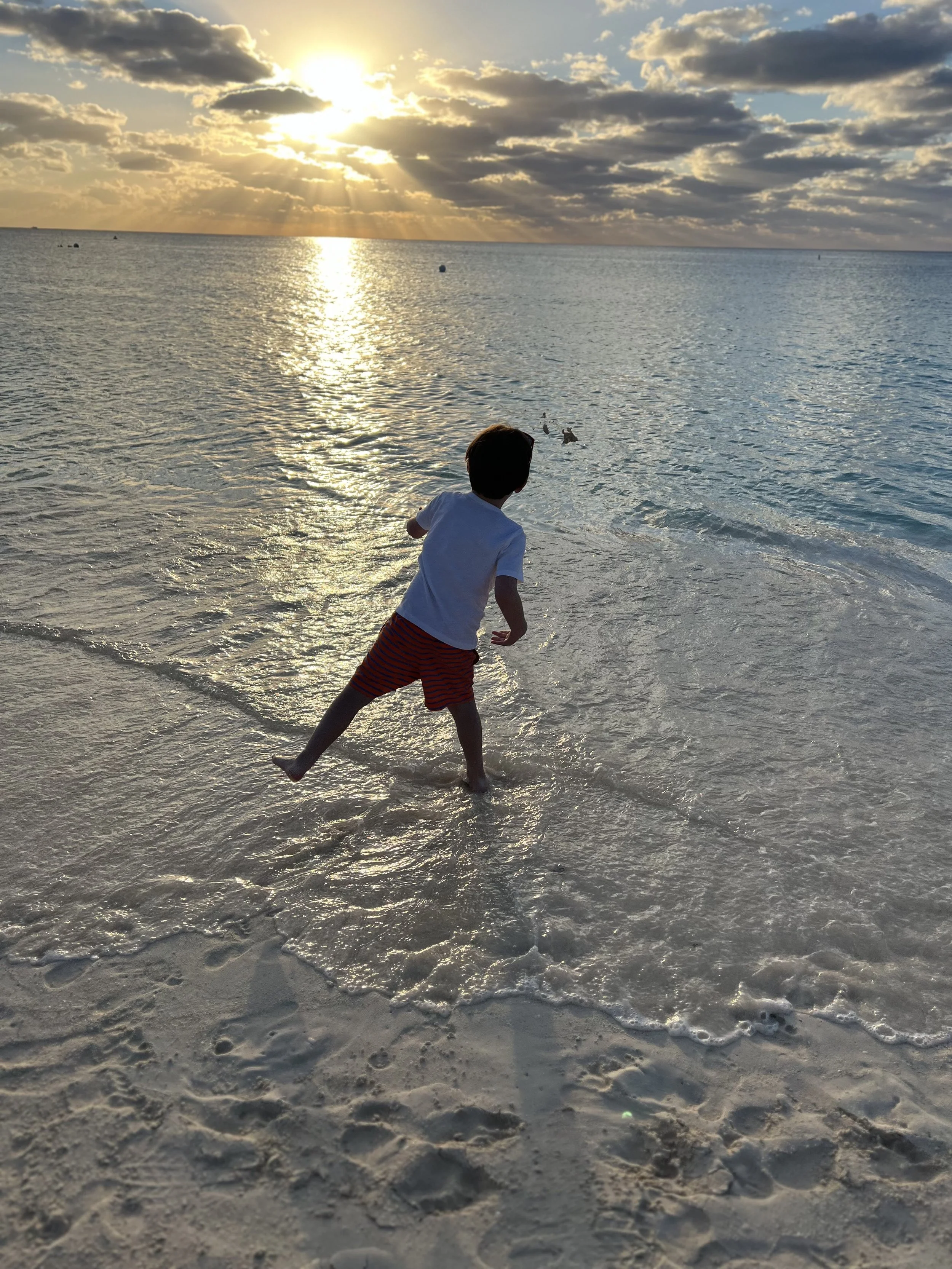The sunsets on the beach with the sun reflecting on the water seven mile beach grand cayman
