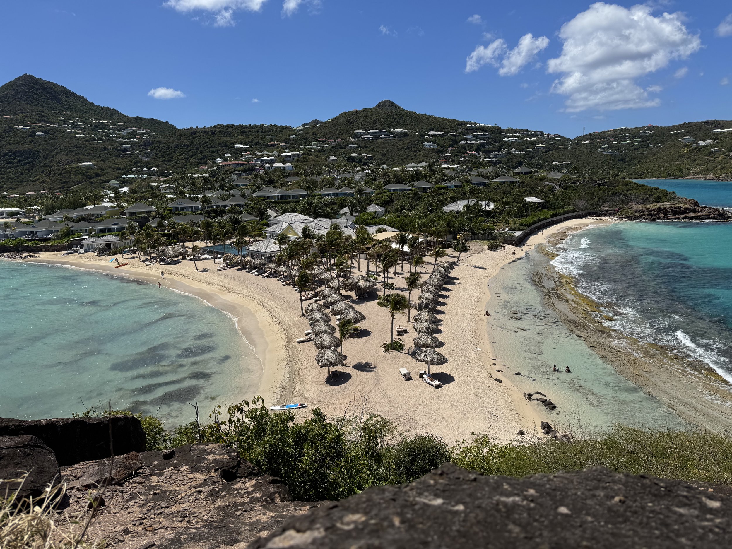 Le Guanahani resort on its private peninsula in Grand Cul-de-Sac, St. Barth, with palapa umbrellas and palms between two beaches