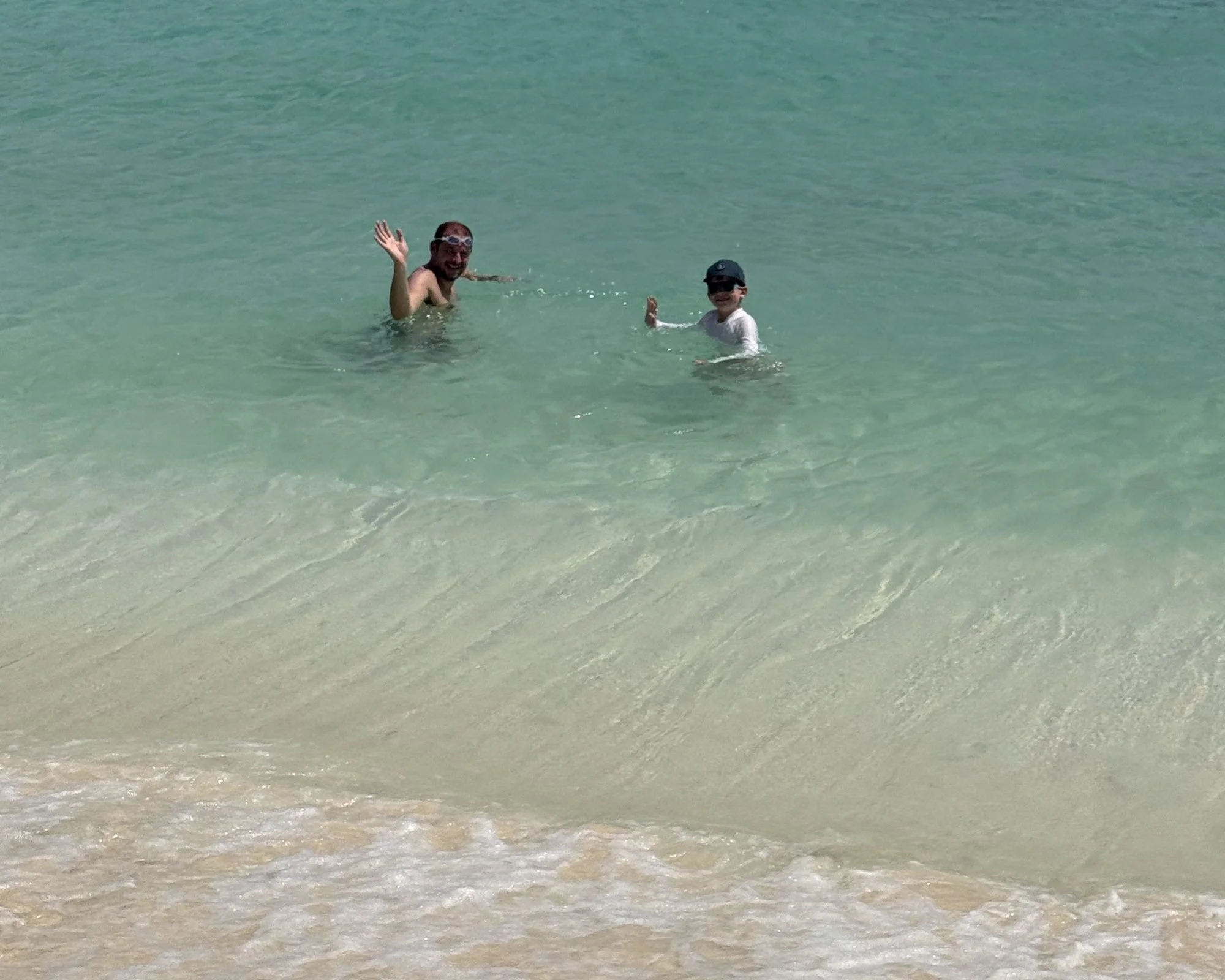 the author's husband and son swimming in turquoise water at cap jaluca