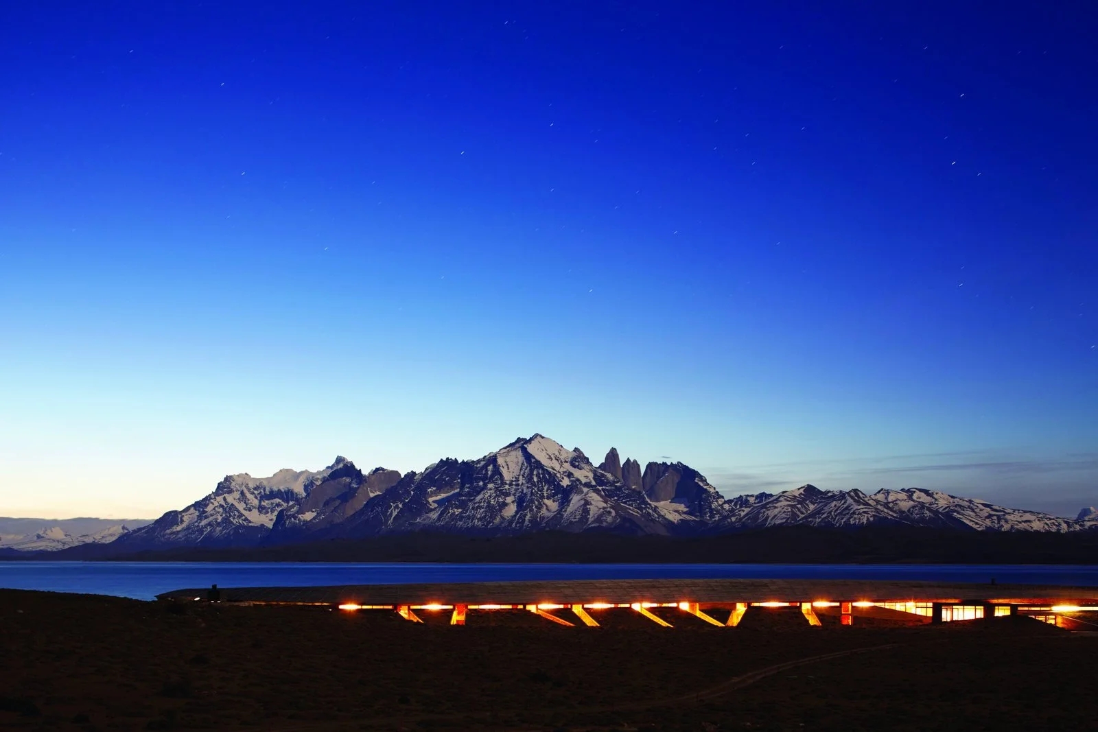 Tierra Patagonia lit at dusk on the shore of Lake Sarmiento with the Paine massif behind