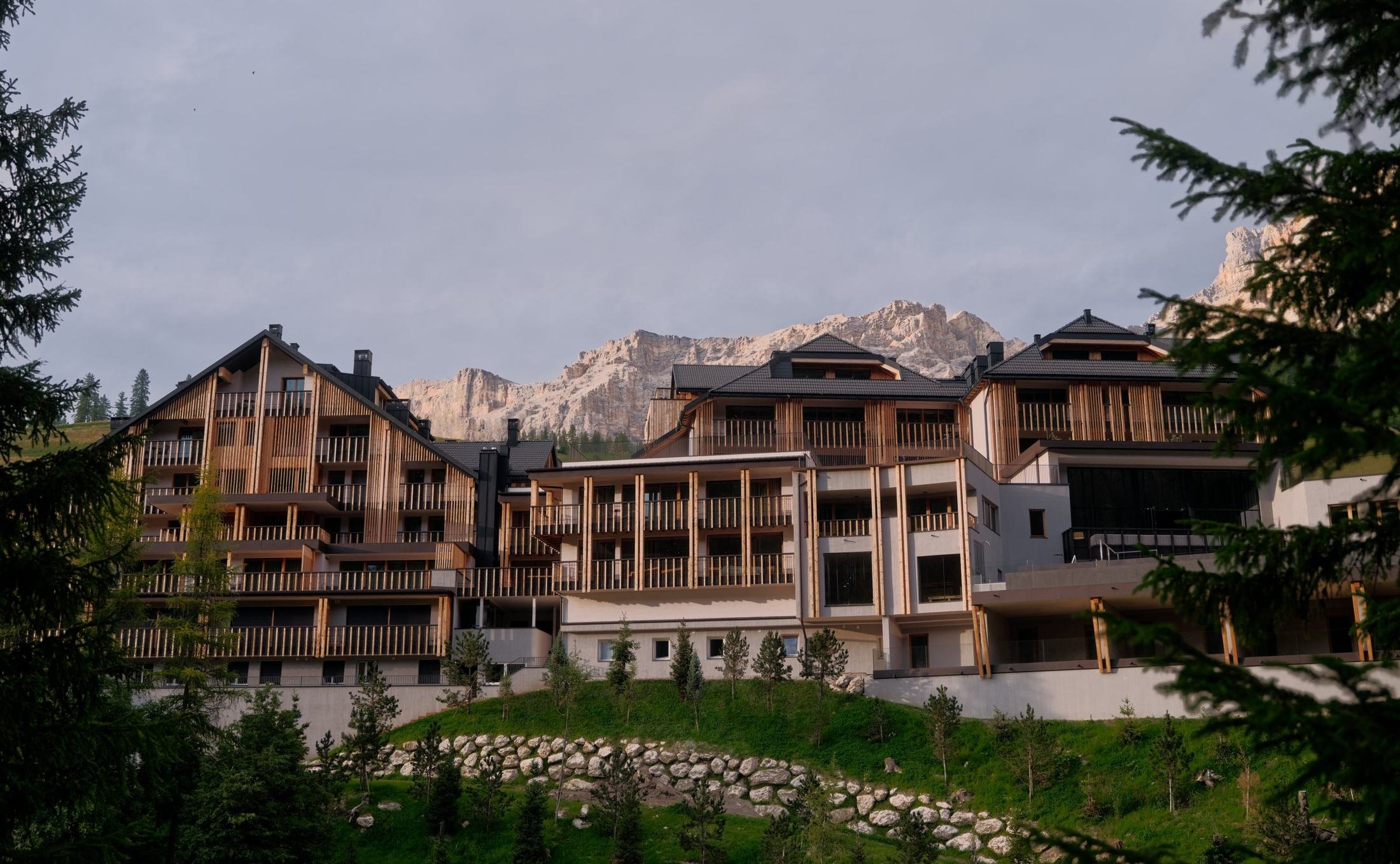 Exterior of Aman Rosa Alpina in San Cassiano with the Dolomites rising behind the hotel