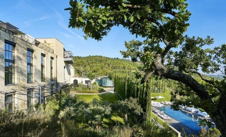 Villa La Coste hotel building and outdoor pool set into the hillside above the vineyards, Provence.