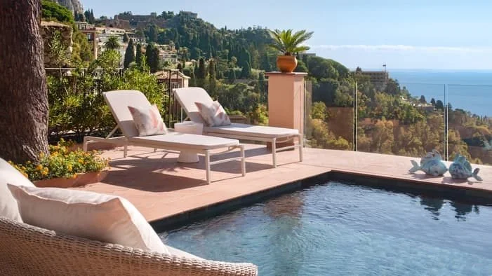Private plunge pool and terrace at a San Domenico Palace pool suite in Taormina, looking over the town and the Ionian Sea