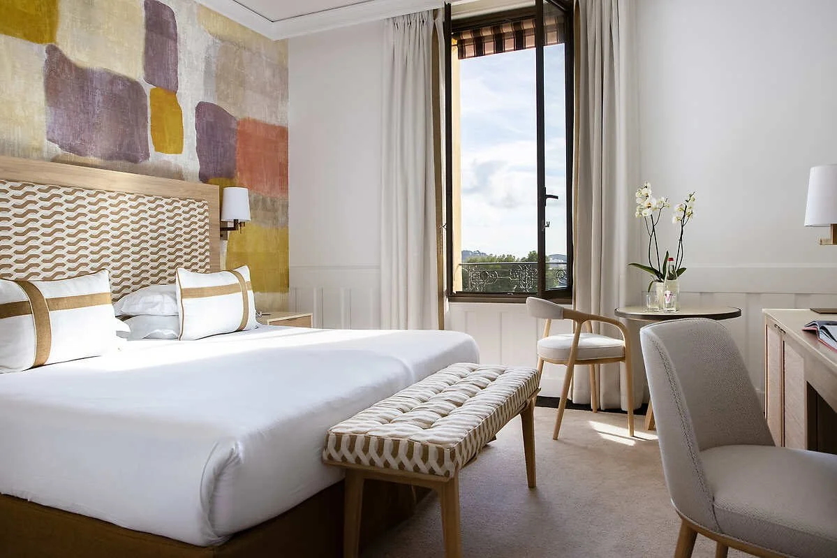 Guest room with abstract artwork above the bed at Royal-Riviera, Saint-Jean-Cap-Ferrat